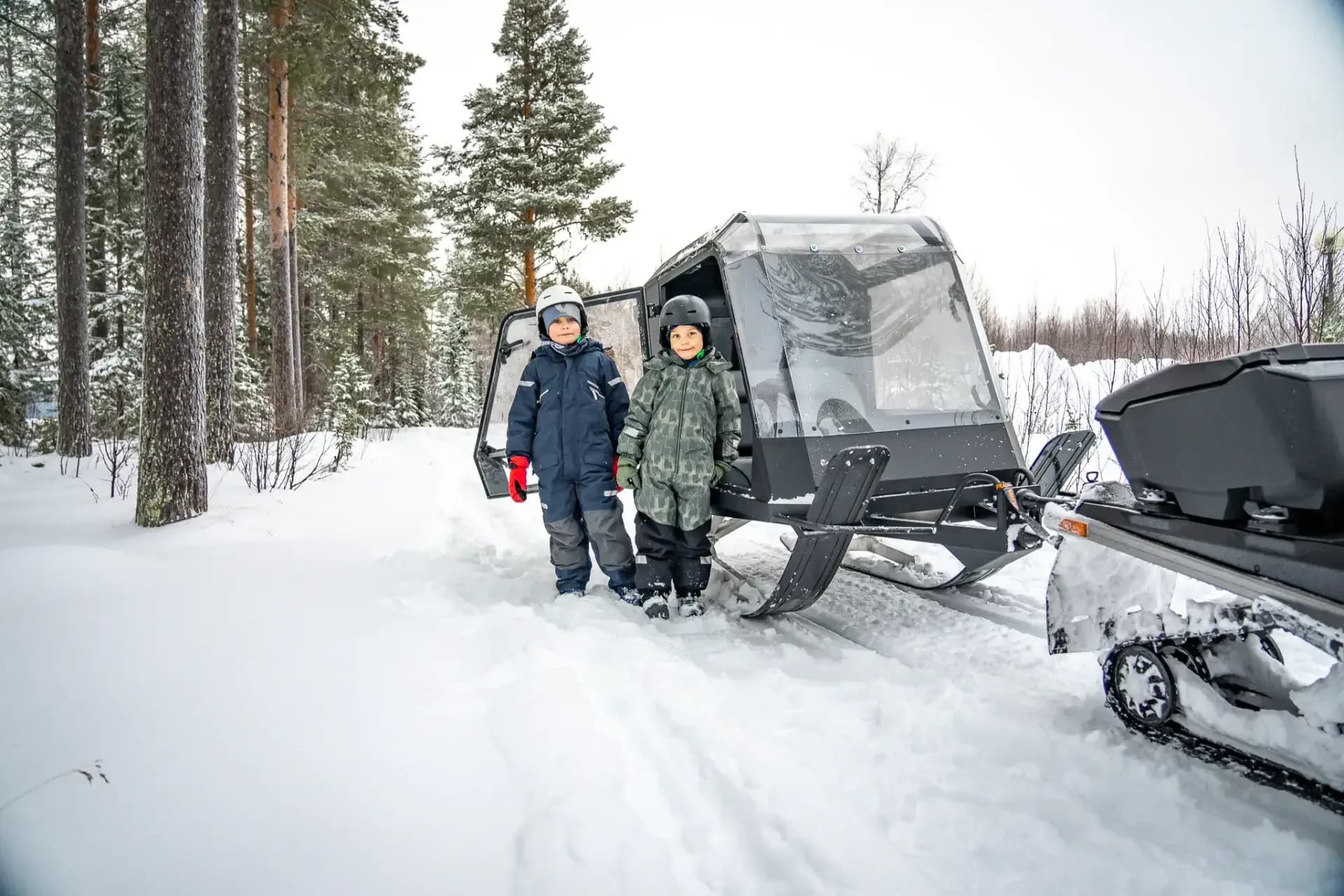 Barn framför Pulkapanorama Expedition i skogen